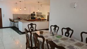 una sala da pranzo e una cucina con tavolo e sedie di Heritage a Quatre Bornes