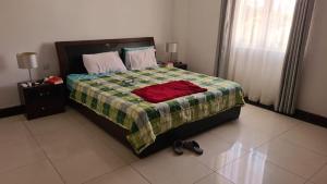 una camera da letto con un letto con una camicia rossa sopra di Heritage a Quatre Bornes