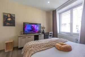 a bedroom with a bed and a flat screen tv at Chambres de luxe SDB WC Privés in Liège