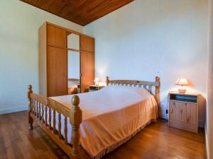 a bedroom with a large bed with a wooden headboard at Sénezergues Garden Hideaway in Cassaniouze