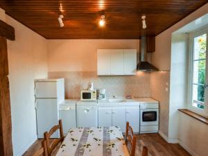 a kitchen with a table and a sink and a refrigerator at Sénezergues Garden Hideaway in Cassaniouze