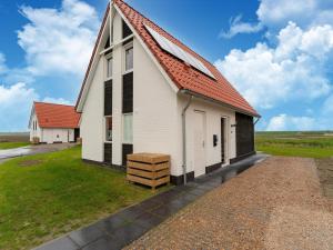 a white church with an orange roof at Modern holiday home by the sea with sauna in Scherpenisse