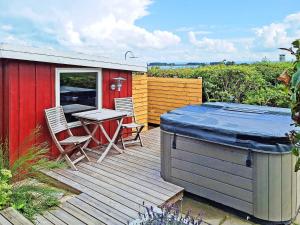 a deck with a hot tub and a table and chairs at 6 person holiday home in Lemvig in Lemvig