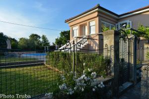 a fence in front of a house with flowers at Apartment Villa Oliva in Gostinjac