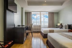 a hotel room with two beds and a desk and a window at Gelian Hotel in Machakos +38 photos