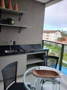 a kitchen with a table and chairs and a window at FLAT BEACH CLASS SUMMEr PORTO DE GALINHAS in Porto De Galinhas