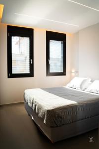 ein Schlafzimmer mit einem Bett und zwei Fenstern in der Unterkunft The Modern in Eleusis + 87 Fotos
