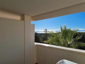 a balcony with a view of a palm tree at Golfside Luxury at Las Colinas in Orihuela Costa
