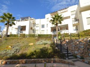 a building with palm trees in front of it at Golfside Luxury at Las Colinas in Orihuela Costa