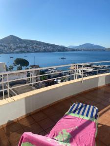 een stoel op een balkon met uitzicht op het water bij Saranda Sea View Apartment in Sarandë