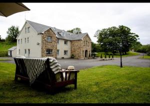 a chair sitting in the grass in front of a house at Donegal Manor in Donegal