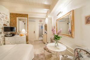 Zimmer mit einem Tisch, Stühlen und einem Spiegel in der Unterkunft Villa Segalla in Rovinj