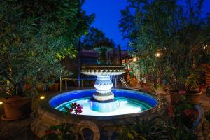 a fountain in the middle of a garden at night at Hotel Centrál Šaľa in Šaľa
