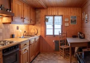a kitchen with wooden cabinets and a sink and a table at Cozy chalet in Kandersteg in Kandersteg