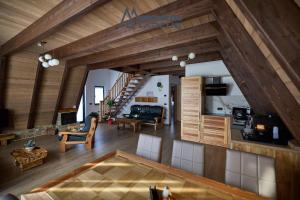 a large living room with wooden ceilings and a staircase at Cabanele Marcus in Statjunea Borsa