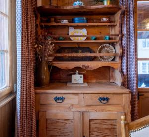 a wooden dresser in a room with a window at Cozy chalet in Kandersteg in Kandersteg +76 photos