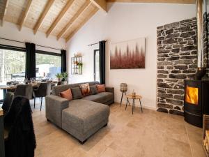a living room with a couch and a fireplace at Modern Wellness Stay, Érezée in Érezée