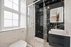 a bathroom with a sink and a mirror at Cambridge Court Central Flats in London