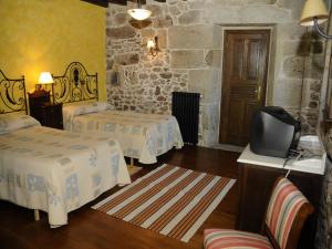 a hotel room with two beds and a television at Casa Casarellos in Casarellos +22 photos