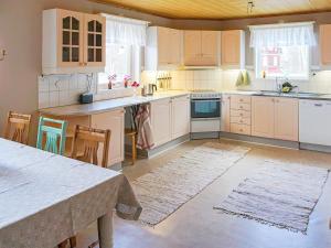 a kitchen with white cabinets and a table with chairs at 5 person holiday home in Billingfors in Billingsfors