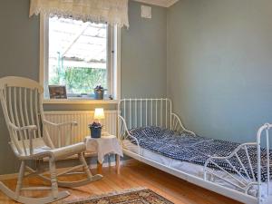 a bedroom with a bed and a chair and a window at 5 person holiday home in Billingfors in Billingsfors