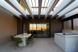 ein Zimmer mit Tisch und Stühlen und einer Badewanne in der Unterkunft The Modern in Eleusis