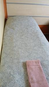a close up of a bed with a pink towel on it at Cozy cottage at park de Kniphorst in Anloo