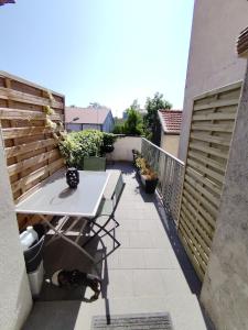 a patio with a table and a dog on a balcony at Parenthèse Chic et Cosy in Nancy