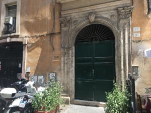 ローマにあるPiazza Navona Cornerの正面に駐輪するバイクの建物の緑の扉