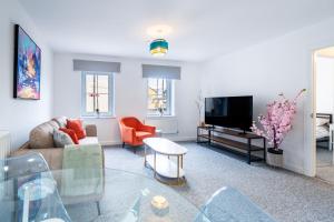 ein Wohnzimmer mit Sofa und Fernseher in der Unterkunft Two-bed Ground Floor Flat in Caerphilly Town Centre in Caerphilly