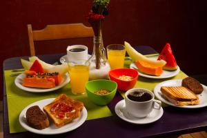 
a table topped with plates of food and drinks at Rio Forest Hostel in Rio de Janeiro
