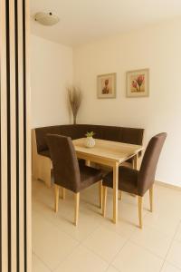 a dining room with a wooden table and chairs at Domček Lodenica in Šintava
