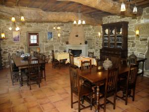 a dining room with tables and chairs and a stone wall at Casa Casarellos in Casarellos