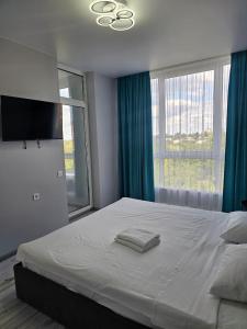 a bedroom with a large bed with a large window at Nyvky Like Home - Файна Таун із сезонним басейном - Кв 149 in Kyiv