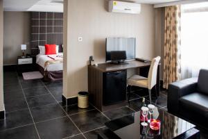 a hotel room with a bed and a desk with a television at Gelian Hotel in Machakos