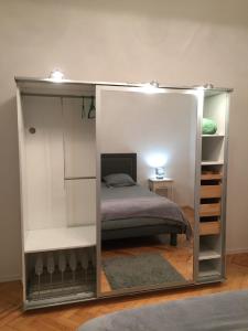 a bedroom with a bed and a mirror at L'écrin vert - proche gare, piscine , tennis, wifi in Labouheyre +13 photos
