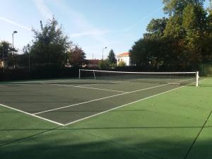 a tennis court with a net on top of it at L'écrin vert - proche gare, piscine , tennis, wifi in Labouheyre