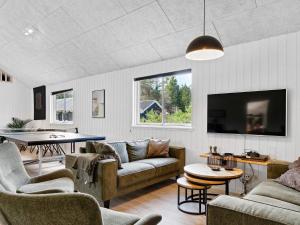 a living room with a couch and a tv at 5 star holiday home in Frederiksværk in Frederiksværk