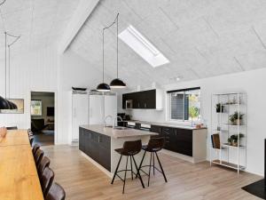 a kitchen with black cabinets and a kitchen island with stools at 5 star holiday home in Frederiksværk in Frederiksværk