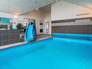 a swimming pool with a slide in a building at 16 person holiday home in Hasselberg in Kappeln +19 photos