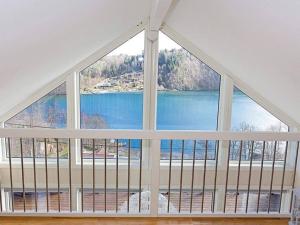 a large window with a view of a lake at 4 star holiday home in Lyngdal in Lyngdal +19 photos
