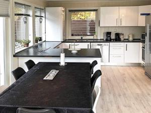 a kitchen with a table and chairs in it at 4 star holiday home in Lyngdal in Lyngdal