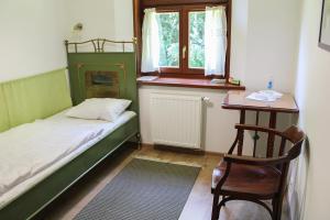 a bedroom with a bed and a chair and a table at Dom gościnny w Bartniku in StrÃ³Å¼e