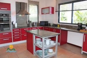 a kitchen with red cabinets and a island in it at OurMadeira - The Designhouse, contemporary in Arco da Calheta
