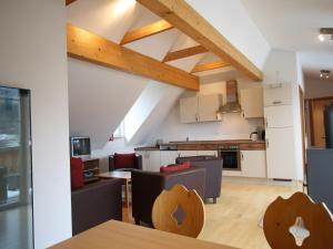 an attic kitchen and living room with wooden ceilings at Apartment St Margarethen near Ski Lift in Sankt Margarethen im Lungau +32 photos