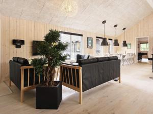 a living room with two couches and a potted plant at 5 star holiday home in Nexø in Bedegård