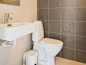 a bathroom with a white toilet and a sink at 5 star holiday home in Nexø in Bedegård +37 photos