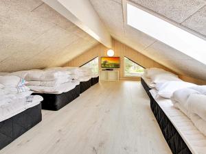 a large room with four beds in it at 5 star holiday home in Nexø in Bedegård