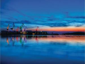 a sunset over a body of water with cranes at Holiday Home in Vodnjan near the Sea in Vodnjan