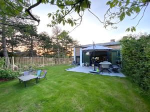 a garden with a tent and chairs in a yard at Holiday Home Nieuwvliet near Beach in Nieuwvliet-Bad
